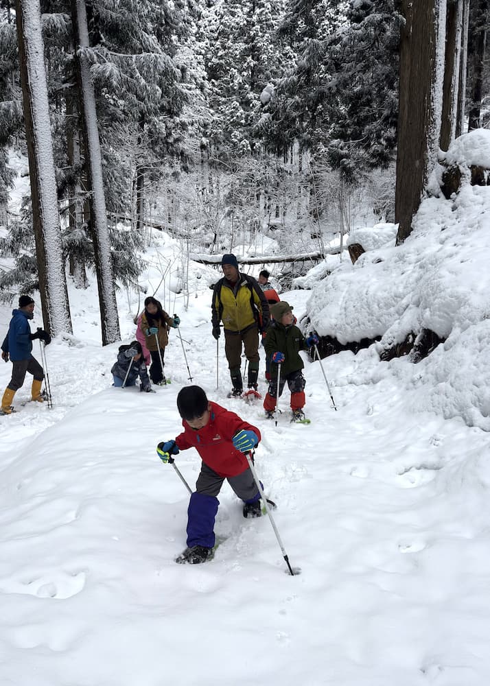 スノーシューを履いて登山する子供たち